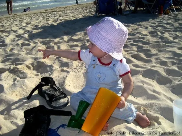 toddler sitting on a beach in playa del carmen