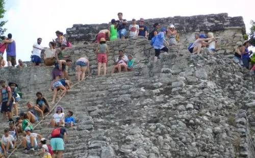 Mayan Riviera Bucket List With Kids tourists climb the ruined pyramid at coba