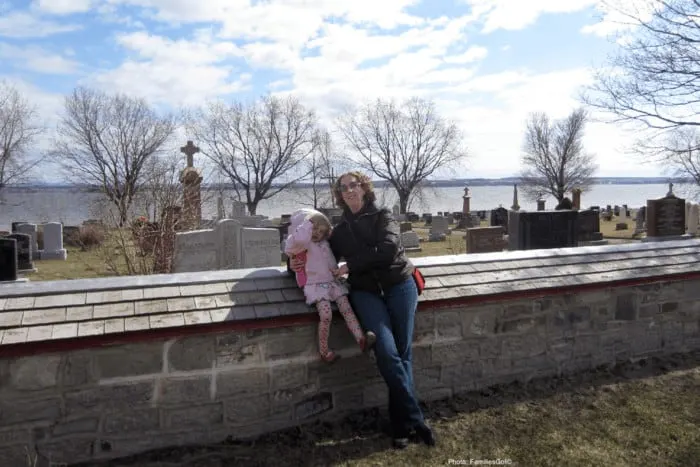 mother and child in front of a scenic graveyard on ile d'orleans