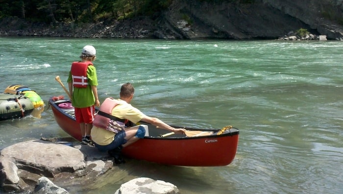 Putting canoes in the water for a camping adventure near banff