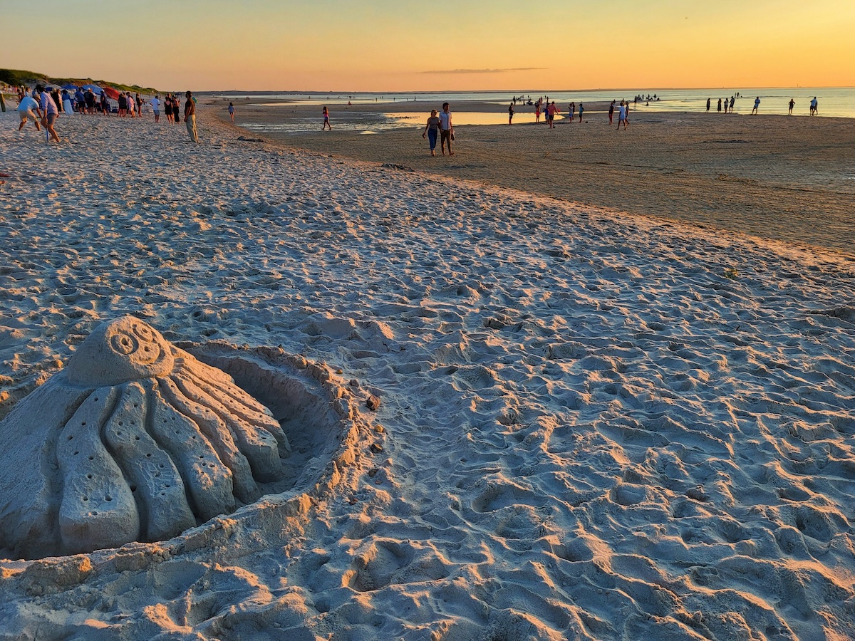 Cape Cod: 11 Fun, Cheap & Easy Summer Things To Do With Kids: Families frolic on Mayflower Beach behind an octopus sanctuary sculpture.