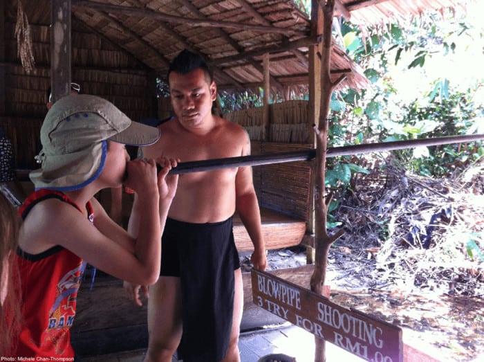 Sarawak cultural village, learning to use a blow-dart gun