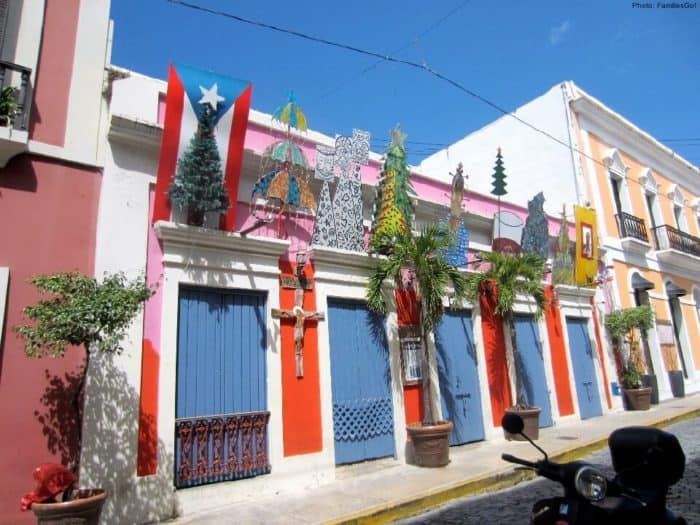 A Typical Street In Old San Juan With Brightly Colored Houses And Christmas Type Decorations.