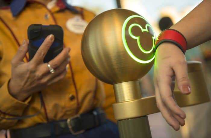 A Walt Disney World Resort guest uses a MagicBand to enter Magic Kingdom theme park in Lake Buena Vista, Fla. Guests also can use MagicBands to enter their Disney Resort hotel room, buy food and merchandise, enter Walt Disney World Resort theme parks and water parks, access their selected FastPass+ experiences and connect to Disney's PhotoPass. MagicBands are part of the new MyMagic+, which has the ability to connect nearly all aspects of the guest vacation experience at Walt Disney World Resort.