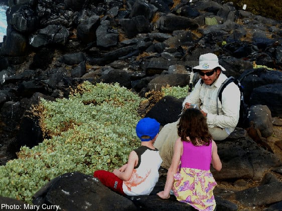 A guide talks to two young children on one of the galapagos islands