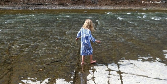 Seasons change quickly in ithaca. Here a girl splashes in water with snow still on the ground.