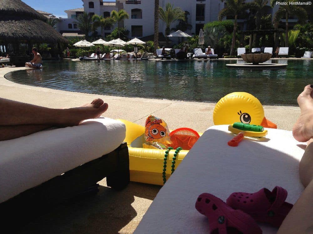 It helps to be resourceful when you are on vacation with a toddler. Define a play area with lounge chairs and floaties.