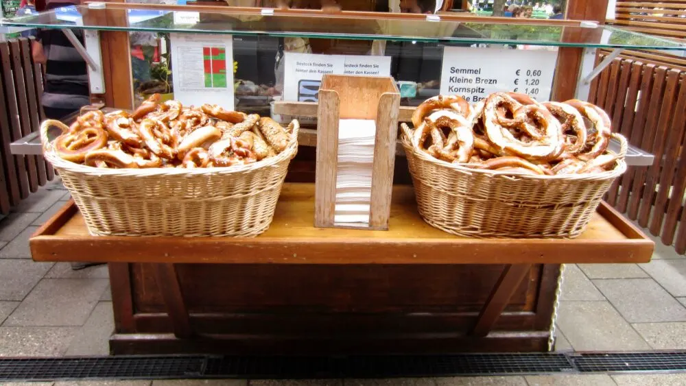Munich: 10+ Things To Do &Amp; See That Your Whole Family Will Love Baskets of bavarian pretzels tempt visitors to the beer garden in munich's english garden park.