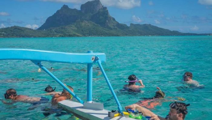 snorkeling in crystal clear blue water off of Bora Bora