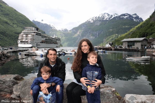 a family about to set sail on the msc sinfonia through the nordic fjords (both in the background).