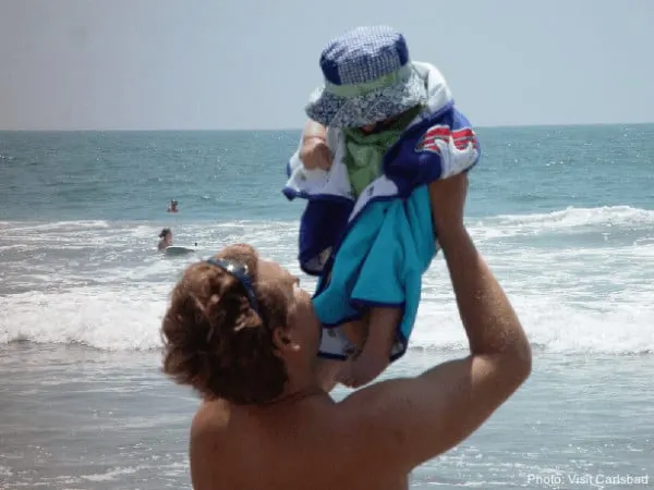 a father and baby on the beach on carlsbad