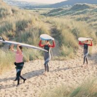 carrying surfboards through the heather in Wales