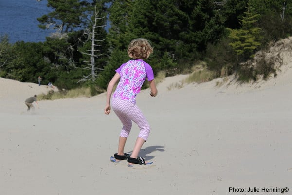 A girls plays in the oregon dunes, outside of florence.