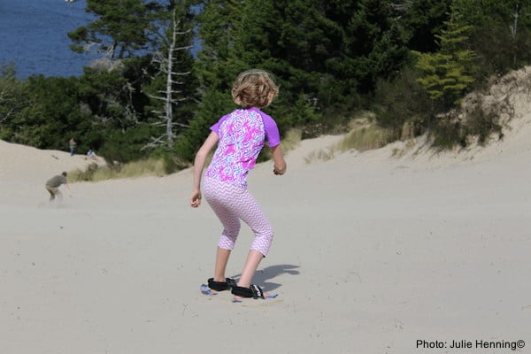 A girls plays in the oregon dunes, outside of florence, just off of oregon's coast route 101.
