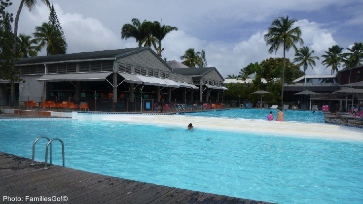 The Pool At Le Creole Resort In Guadeloupe With Chairs And The Patio Bar Around It. 