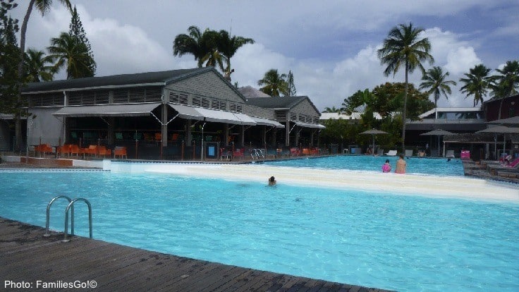 The pool at le creole resort in guadeloupe with chairs and the patio bar around it.
