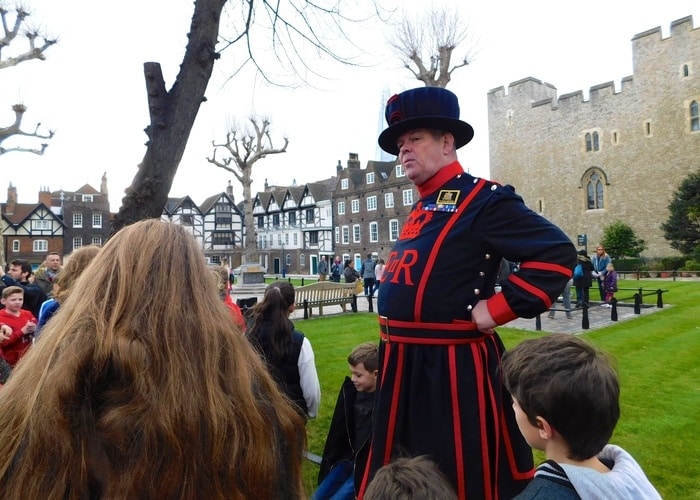 A beefeater entertain kids during a tower tour