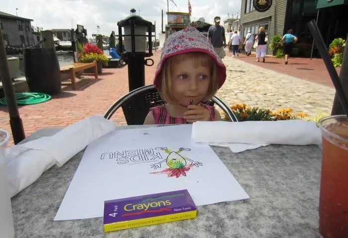 a preschooler sits at bowen's wharf restaurant with crayons and a kids menu.