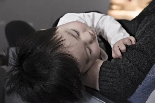 toddler falling asleep in mom's lap