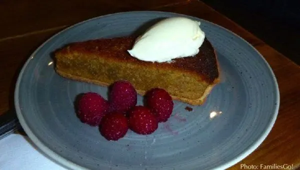 a slice of treacle tart with whipped cream and rasberries in edinburgh.