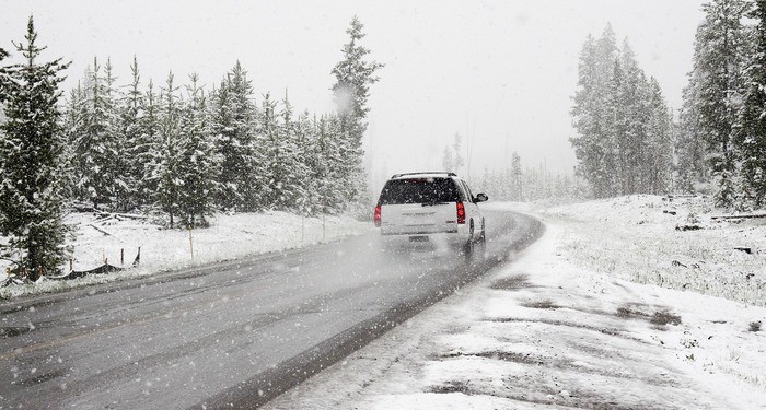 A family car is driving through snow to their relatives' house for christmas