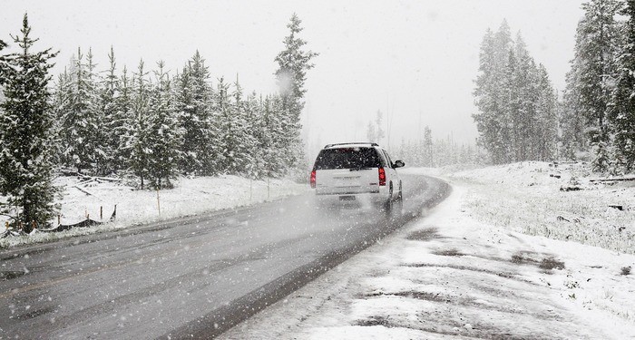 a family car is driving through snow to their relatives' house for Christmas