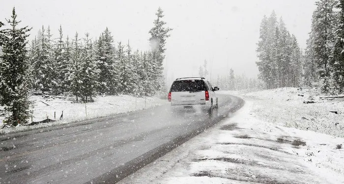 a family car is driving through snow to their relatives' house for christmas