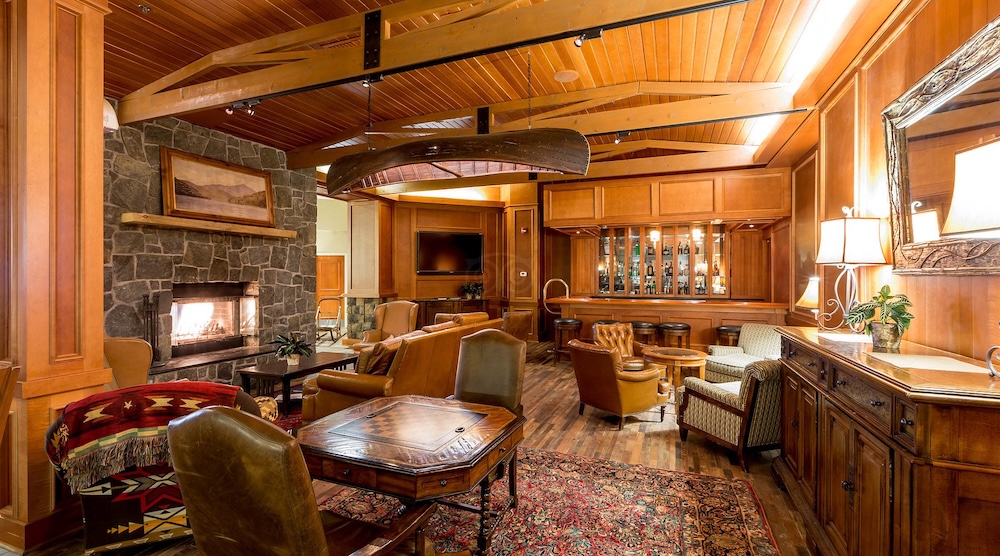 High peaks resort has a spacious and comfortable lounge with conversational groupings of furniture arund a two-sided fireplace.