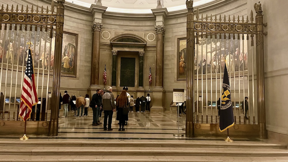 A dad and teen daughter enter the rotunda of the national archives where the america's founding documents can be viewed.