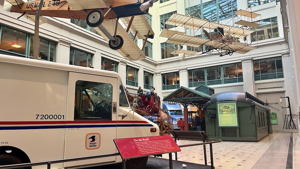 The u. S. Postal museum's center space celebrates the trucks, trains, wagons and planes that have delivered mail over time
