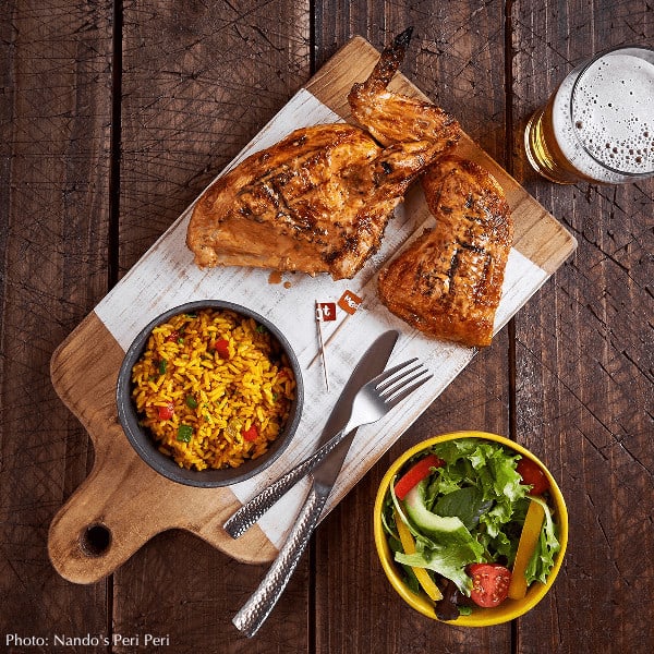 Good, spicy peri peri chicken from nando's with yellow confetti rice, a salad and beer.