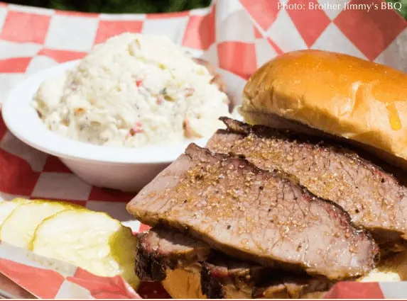 the brisket at brother jimmy's bbq with pickles and a side of cole slaw.