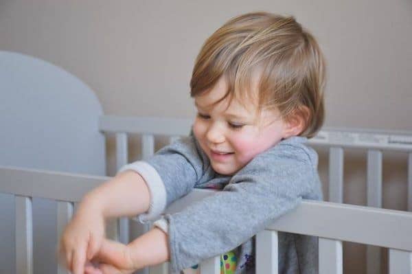 A toddler wide awak in his crib