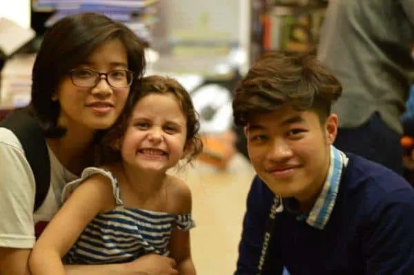 two hanoikids tour guides with a young customer.