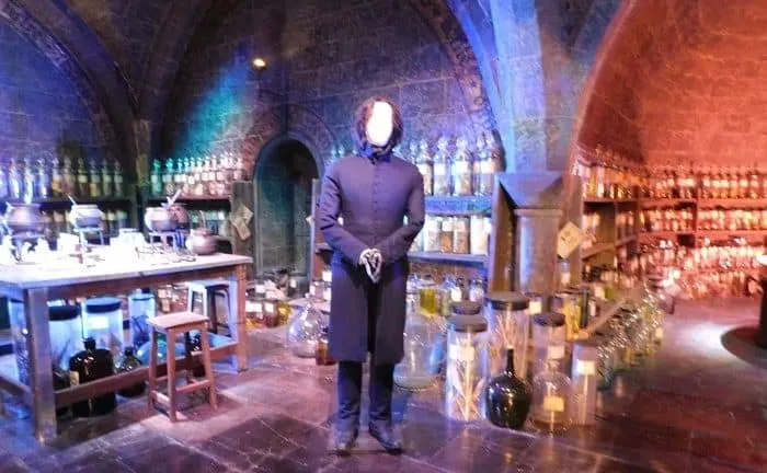 a mannekin in snape's costume and wig poses in the potions classroom at the warner brothers tour