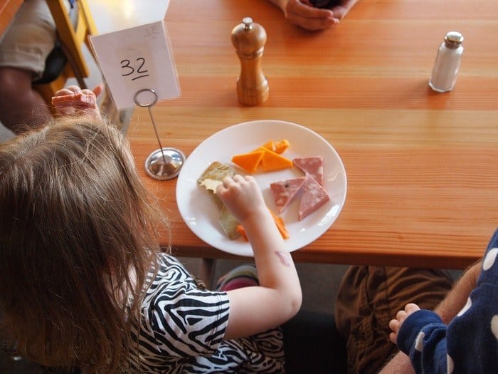 Girl eating kid food in a restaurant