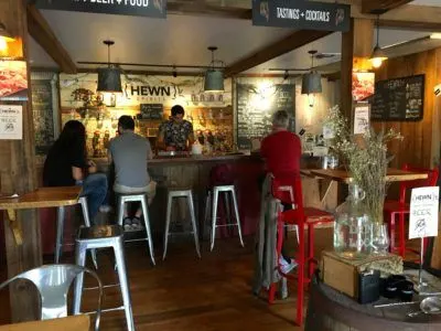 A Cool Couple's Getaway To New Hope, Pa People sitting at the bar in the wood-paneled tasting room at hewn spirits
