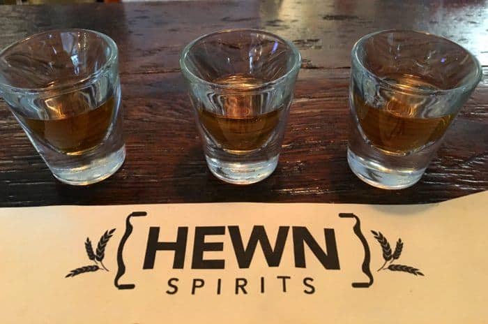 A flight of bourbon, rye and rum in shotglasses at hewn spirits at peddler's village in new hope.