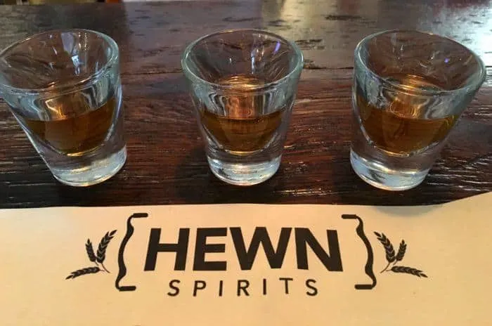 a flight of bourbon, rye and rum in shotglasses at hewn spirits at peddler's village in new hope.