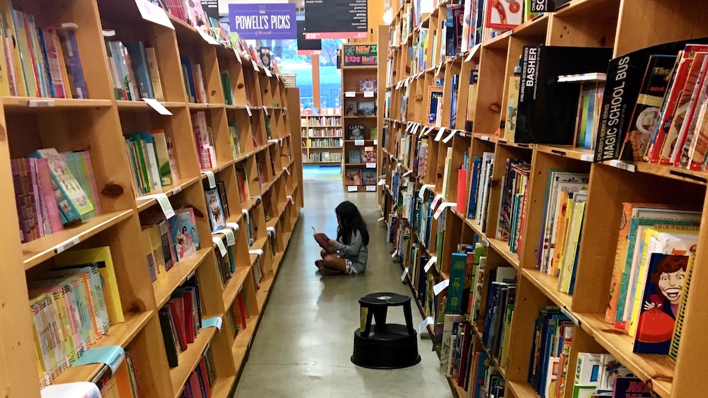 48 Hours In Portland, Or: 15 Things To Do, See &Amp; Eat With Tweens &Amp; Teens A girl sits in the rose room at powell's city of books, which has a huge selection of tween and teen favorites.