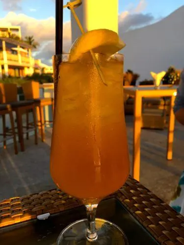 a rum swizzle cocktail at sunset  at the 1609 restaurant in hamilton, bermuda