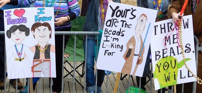 signs to attract beads at a lafayette fat tuesday parade