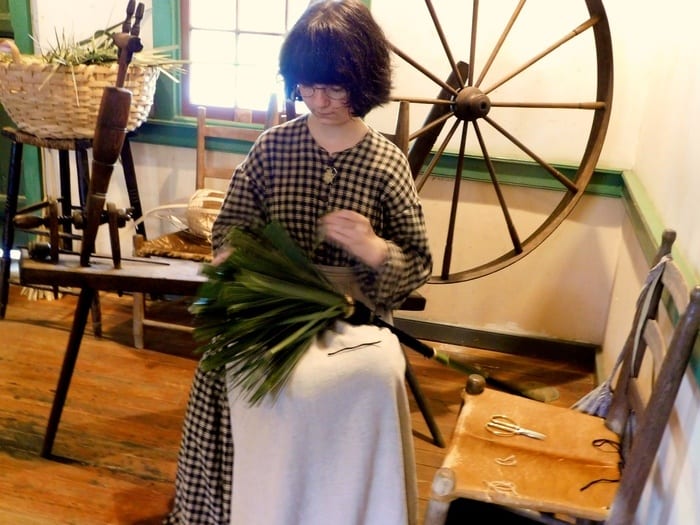 at historic vermillionville near lafayetter a costumed girl makes a broom the old-fashioned way,