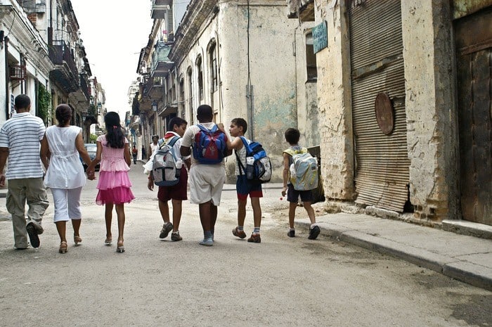 Kids, teens and parents explore a cuba city street.