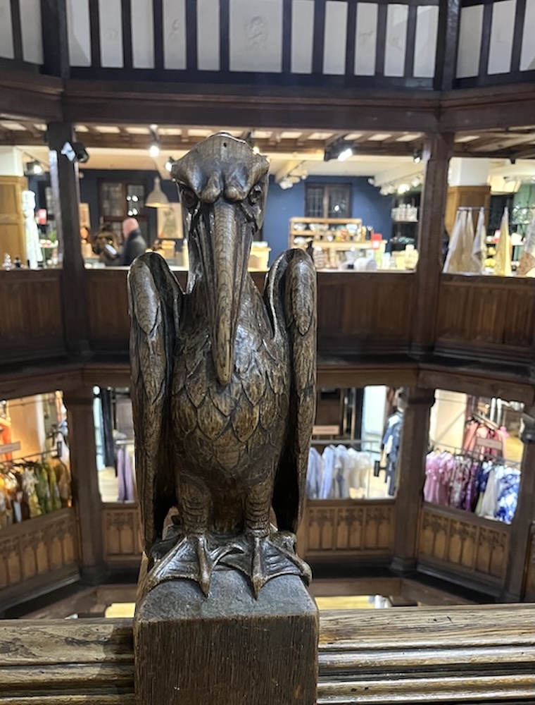 Liberty london is a tudor-style department store where wooden animals like the pelican, watch over shoppers.