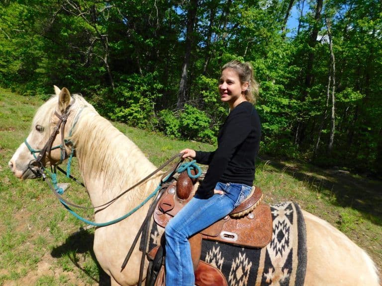 A woman riding a horse with north mountain outfitters