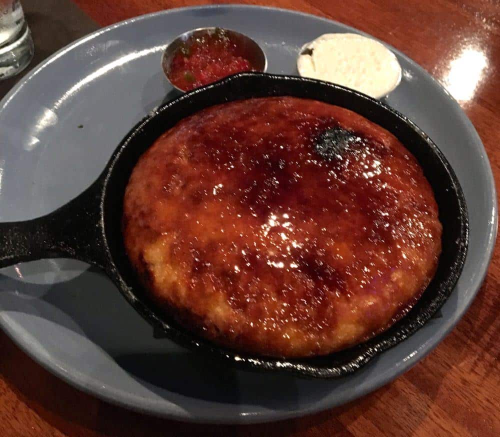 Creme brulee corn bread is a must-have appetizer that zynodoa serves in a cast-iron skillet.