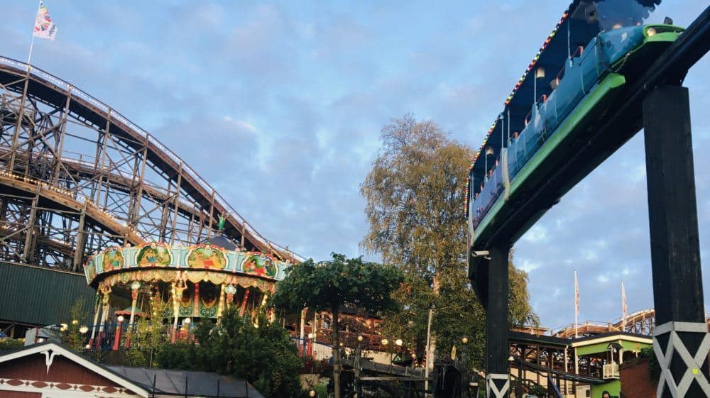 The tram, carousel and wooden roller coaster at linnanmaki amusement park.