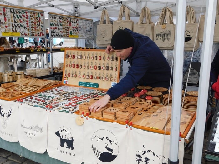 A vendor sells birchwood crafts in market square