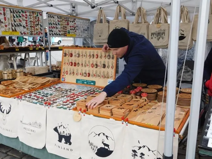 A vendor sells birchwood crafts in market square